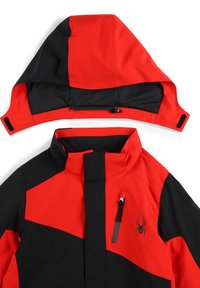 Giacca rossa e nera con colletto alto, cappuccio staccabile e tasca sul petto con zip. Presenta una texture liscia e un blocco di colore angolare.
