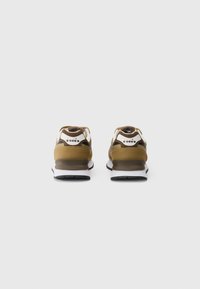 Sneakers in brown and beige with mesh and synthetic materials. Features padded collar, pull tab, and thick white midsole. Black outsole patterns.
