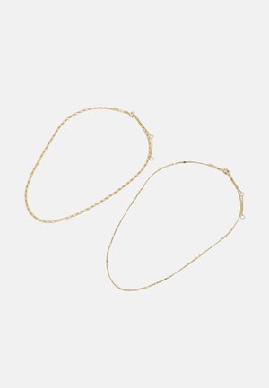 Guldmetal halskæder med varierende kædedesign; den ene har ensartede led, mens den anden har et struktureret, delikat mønster.