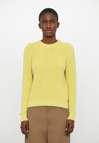 Sitrongul genser strikket med rund hals og ribbet tekstur, med lange ermer og en lett cropped passform.