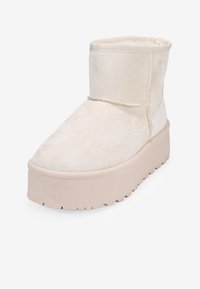 Beżowe botki z faux zamszu do kostki, z okrągłym noskiem, grubą platformą i przeszyciami wzdłuż górnej szwy.