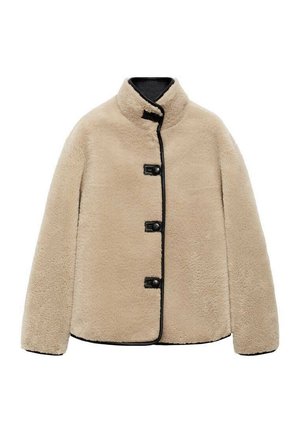 Beige Kunstfelljacke mit hohem Kragen, schwarzem Besatz und vier schwarzen Knöpfen. Sie hat eine kastige Form und eine weiche, strukturierte Oberfläche.