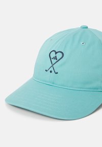 Ljusblå keps i strukturerad tyg med ett marinblått broderat hjärta och korsade golfklubbor som logotyp på framsidan. Justerbar rem på baksidan.