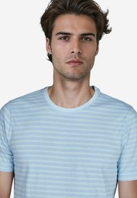 Hellblau gestreiftes T-Shirt mit Rundhalsausschnitt und kurzen Ärmeln. Der Stoff wirkt weich und hat gleichmäßig verteilte horizontale Streifen in verschiedenen Farbtönen.