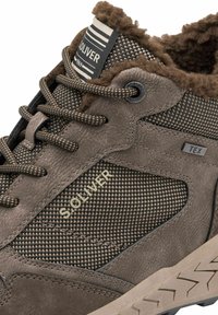 Chaussure de randonnée marron avec un dessus en synthétique texturé, un col légèrement moelleux, des accents à motifs, et une semelle en caoutchouc avec un motif de semelle en zigzag.
