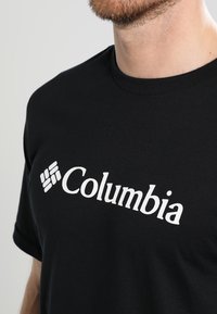 Zwarte katoenen T-shirt met een wit logo met de tekst "Columbia". Ronde hals, korte mouwen, zachte textuur.