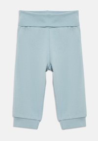Leggings din bumbac de culoare albastru deschis, cu talie largă, manșete înguste și o textură netedă. Fără modele vizibile sau detalii de mobilier.