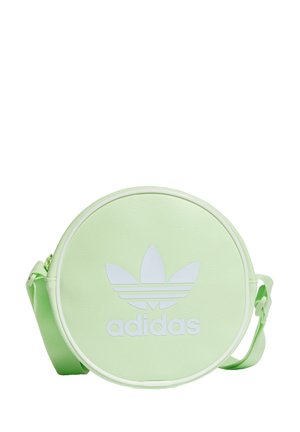 Sac à bandoulière rond vert clair Adidas avec grand logo trèfle blanc et sangle réglable sur fond blanc.
