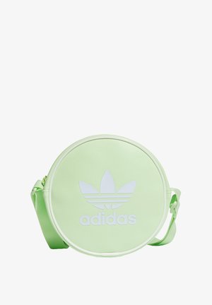 Sac à bandoulière rond vert clair Adidas avec grand logo trèfle blanc et sangle réglable sur fond blanc.