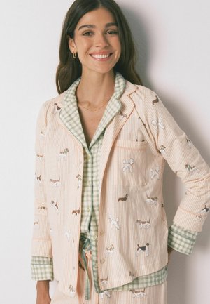 Let let pyjamasæt med et pink stribet design og hundemønstre. Indeholder grønne ternede detaljer og en knaplukning foran.