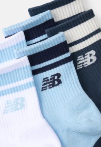 Calzini in misto cotone di colore azzurro chiaro, blu navy e bianco; texture a coste con strisce in contrasto; ognuno presenta un logo vicino alla caviglia.