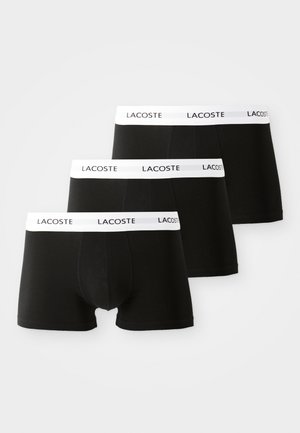 Sorte boxer briefs i trepakning med elastisk hvit midjebånd som har "LACOSTE"-logo, laget av glatt og dekkende stoff.