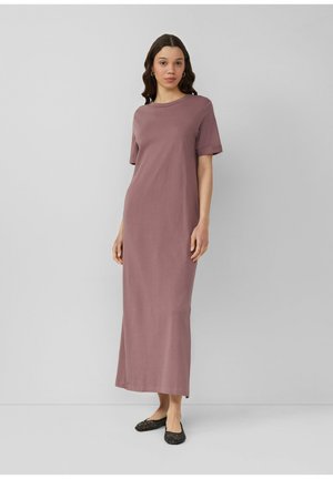 Maxikleid aus mauvefarbenem Stoff mit kurzen Ärmeln, Rundhalsausschnitt, weicher Textur und gerader Silhouette. Kombiniert mit schwarzen Ballerinas.
