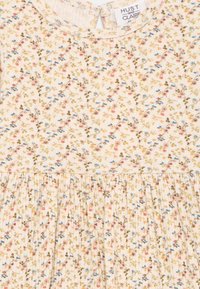 Blumengemustertes Kleid aus weichem Stoff. Lichtbeige Basis mit rosa, blauen und grünen Blumen. Verfügt über einen gerafften Rock und einen Knopfverschluss hinten.