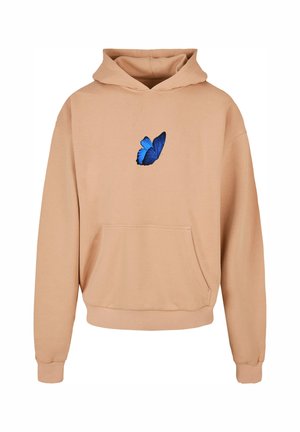 Bež kapuutsärk pehmest kangast, mille keskel on sinine liblikas. Sisaldab eesmist taskut ja soonikuga mansette.