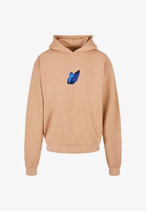 Bež kapuutsärk pehmest kangast, mille keskel on sinine liblikas. Sisaldab eesmist taskut ja soonikuga mansette.