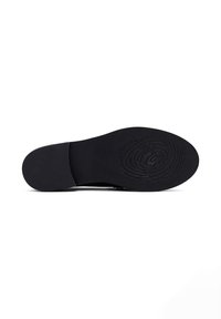 Suola nera di scarpa con una superficie liscia e strutturata. Presenta un motivo circolare al centro e un bordo sagomato per la flessibilità.