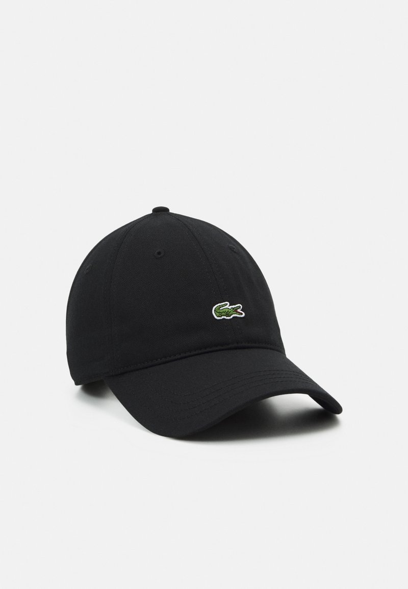 Casquette de baseball noire à visière incurvée, avec un petit logo de crocodile vert brodé sur le côté avant droit.