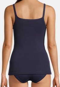 Navy cotton tank top with adjustable spaghetti straps and a fitted design; smooth texture with a straight hem at the hips.