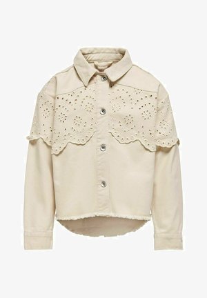 Veste en coton beige avec col pointu, fermeture à boutons sur le devant et détails en dentelle sur les épaules. Ourlet effiloché en bas.