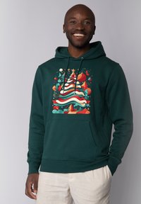 Sweatshirt à capuche vert foncé avec un graphisme de sapin de Noël coloré, accents rouges et turquoise, poche avant et cordons de serrage.