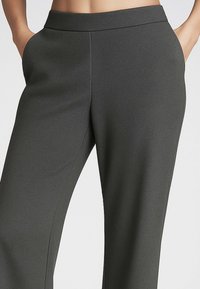 Pantaloni grigi a vita alta con gamba dritta, realizzati in tessuto testurizzato. Presentano tasche laterali e un design della vita senza cuciture.