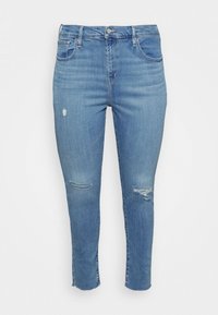 Lyseblå skinny jeans i denimstof med slidte revner på knæene og rå kant ved anklen, fem-lommer design.