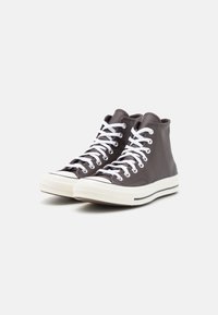 High-top sneakers in dark gray leather with white laces, rubber toe cap, and a white sole featuring a black stripe. Textured side panels.
