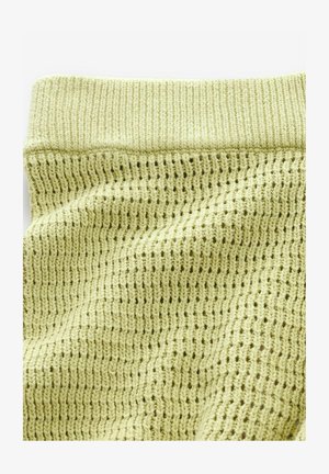 Gaiši zaļš adīts audums ar teksturētu, atvērto austu modeli un cietu ribotu jostasvietu. Mīksts materiāls ar brīvu drāšu krišanu.