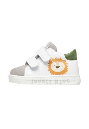 Sneaker per toddler bianco e grigio con tallone verde, due cinturini in Velcro e un volto di leone dei cartoni animati con il testo "Re della Giungla" sulla suola.