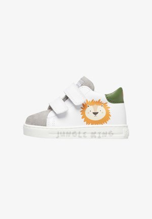 Sneaker per toddler bianco e grigio con tallone verde, due cinturini in Velcro e un volto di leone dei cartoni animati con il testo "Re della Giungla" sulla suola.