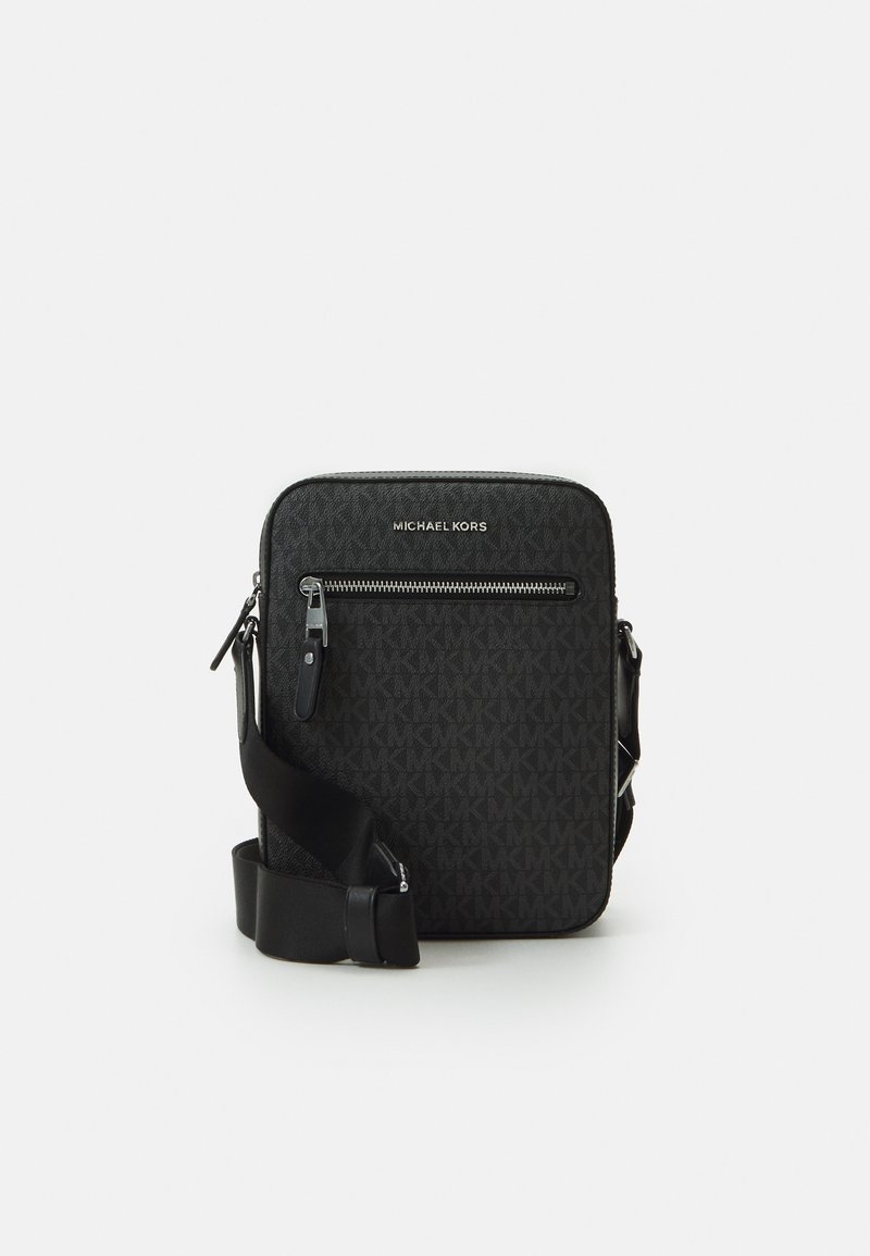 Bolso bandolera negro con un patrón texturizado, logo en la parte superior, bolsillo frontal con cremallera y correa ajustable. Fabricado con material sintético duradero.