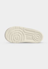 Σόλα λευκού παπουτσιού Nike με κυκλικά και γραμμικά σχέδια πέλματος και το λογότυπο της Nike στο κέντρο.