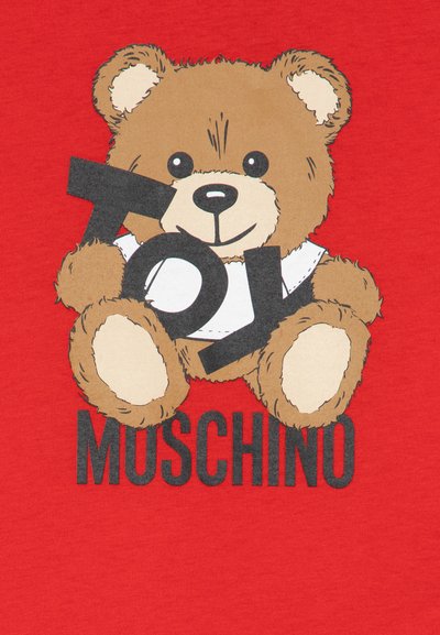 Camisa roja con un oso de dibujo animado que sostiene las palabras "Toy Moschino". El oso tiene una textura suave con pelaje marrón y acentos negros.