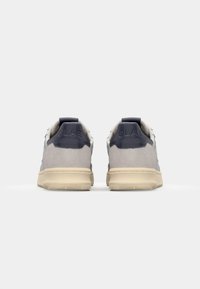 Adidași gri și bleumarin cu un material superior neted, textură de piele întoarsă în contrast, guler căptușit și talpă din cauciuc bej, cu un model de profil texturat.