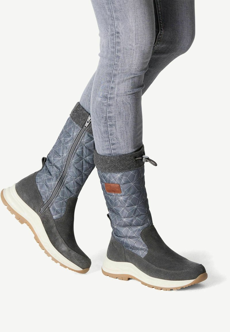 Bottes noires hautes jusqu'aux genoux avec un tige en textile bleu matelassé, un col en feutre gris et une semelle en caoutchouc blanc. Elles sont dotées d'une fermeture éclair sur le côté et d'une accent en cuir.