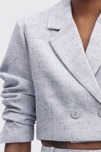 Hellgrauer, taillierter Blazer aus strukturiertem Stoff. Verfügt über eine doppelreihige Front mit zwei Knöpfen und einem klassischen Reverskragen.
