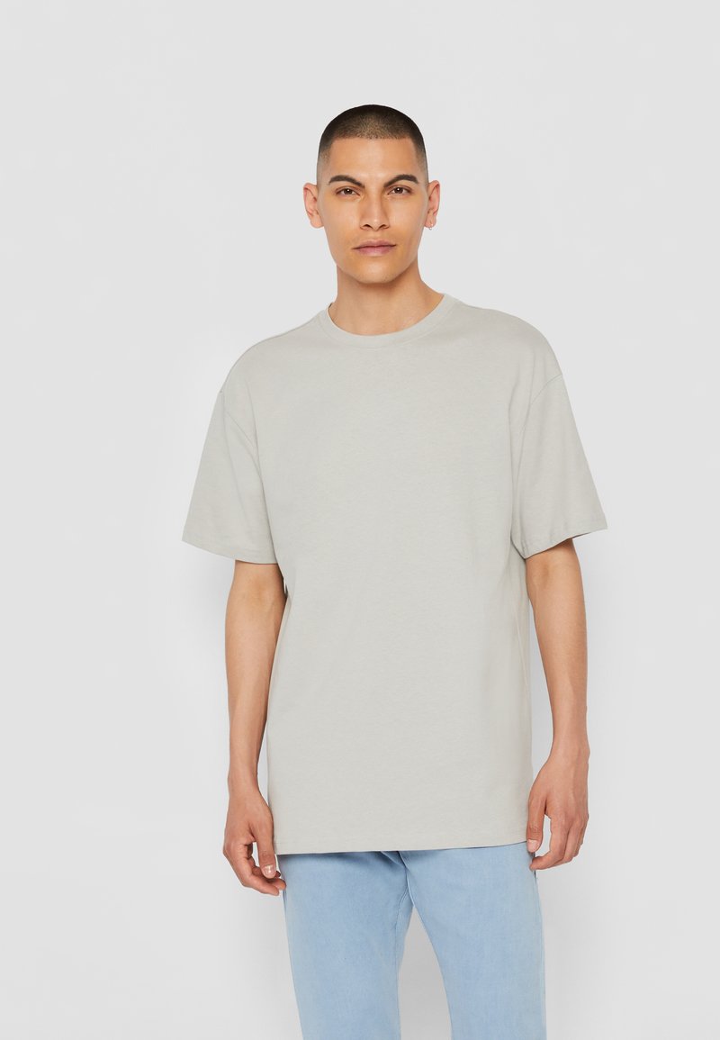 T-shirt grigio chiaro a maniche corte con scollo tondo. Realizzato in cotone morbido, ha una vestibilità comoda e dettagli di cucitura sottili.