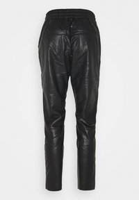 Pantalons en cuir noir avec une taille élastique et deux poches arrière, présentant un design fuselé et une texture lisse.