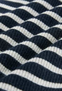 Tessuto a righe blu marino e crema con una morbida texture a coste, che mette in evidenza righe orizzontali alternate larghe e strette.