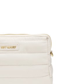 Witte, geplooide tas met gouden rits en hardware. Heeft een logo op een rechthoekig label, met een gladde, gestructureerde oppervlakte.