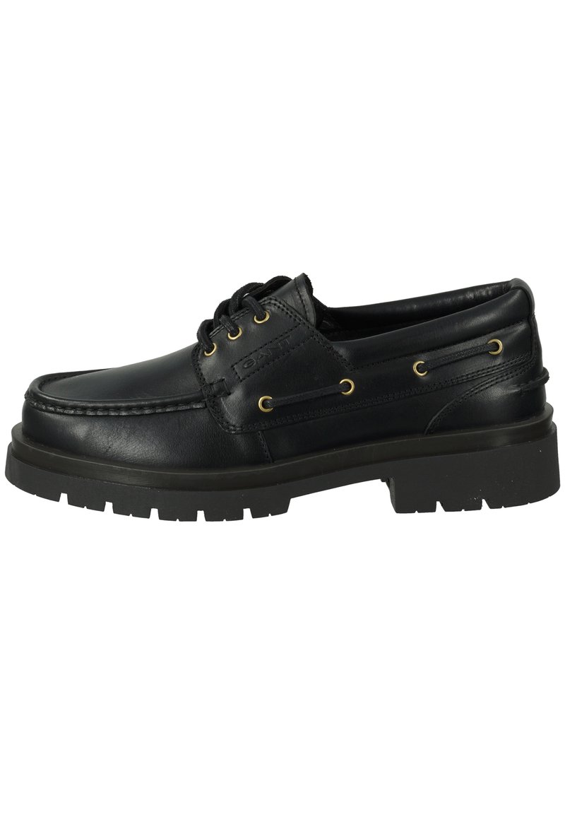 Black leather boat shoe with rounded toe, lace-up front, gold eyelets, and textured rubber sole. Features stitched detailing and a smooth finish.