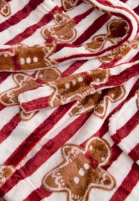 Coperta in pile a strisce rosse e bianche con motivi di omini di pan di zenzero. Tessuto morbido con ricami dettagliati e design accogliente.