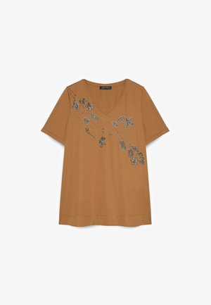 Bruin T-shirt met korte mouwen en V-hals, met een zwart-wit kralenontwerp van bloemranken over de borst en schouder.
