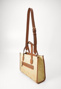 Tan leather shoulder bag with woven fabric in cream and orange pattern. It features two top handles and a front zipper pocket.