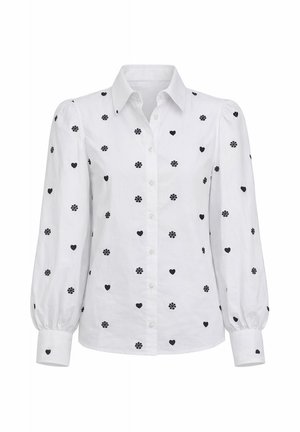 Witte blouse met lange mouwen met zwarte harten- en bloemmotieven, een knoopsluiting aan de voorkant, pofmouwen en een puntige kraag.