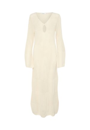 Hosszú, krémszínű ruha V-nyakkal, kulcslyuk formájú nyílással és hosszú, bő szabású ujjal. A teljes felületen textúrázott, bordázott minta látható.