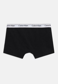 Μαύρα ανδρικά εσώρουχα boxer της Calvin Klein με λευκή ελαστική μέση που φέρει επαναλαμβανόμενο μαύρο λογότυπο Calvin Klein.