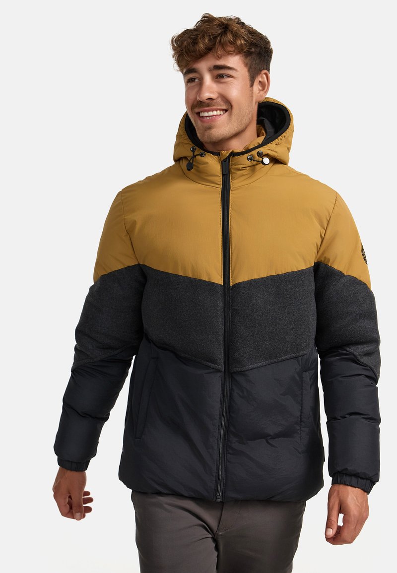 Giacca imbottita con un design a blocchi di colore. La parte superiore è gialla senape, il mezzo è grigio scuro e la parte inferiore è blu navy. Presenta un cappuccio e una chiusura con zip.