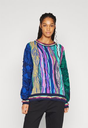 Pull en tricot coloré avec des motifs bleus, verts, roses et jaunes ; design texturé avec un col rond et des poignets côtelés.